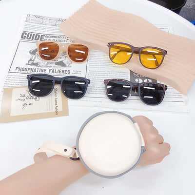 Trendy Foldable Sunglasses For Women TR Polarized Folding Sun Glasses displayed on a table with a hand and a holder.