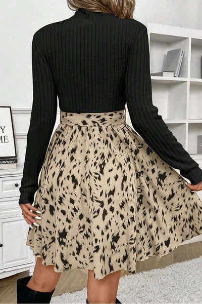 Model wearing a Ribbed Knit Patchwork Printed Belted A-line Dress showcasing a black top and a patterned skirt.