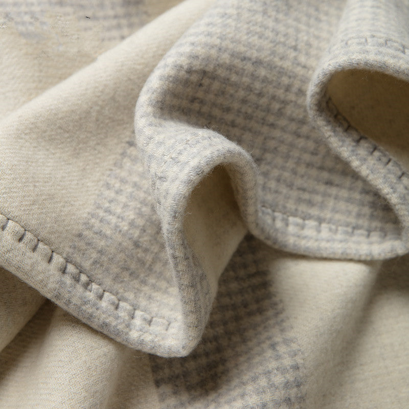 Manta de lã com estampado de mil pássaros, ideal para dormitar no sofá ou no escritório com ar condicionado.