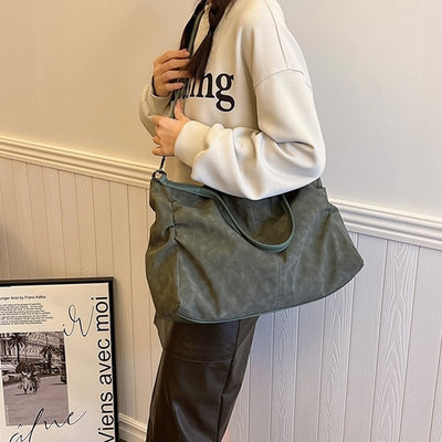 Woman holding a versatile large-capacity women's bag in a casual outfit with a stylish modern design.