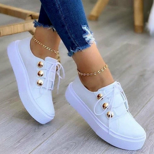 Light Breathable Female Running Shoes Casual Women Sneakers in white with gold accents, paired with ripped jeans.