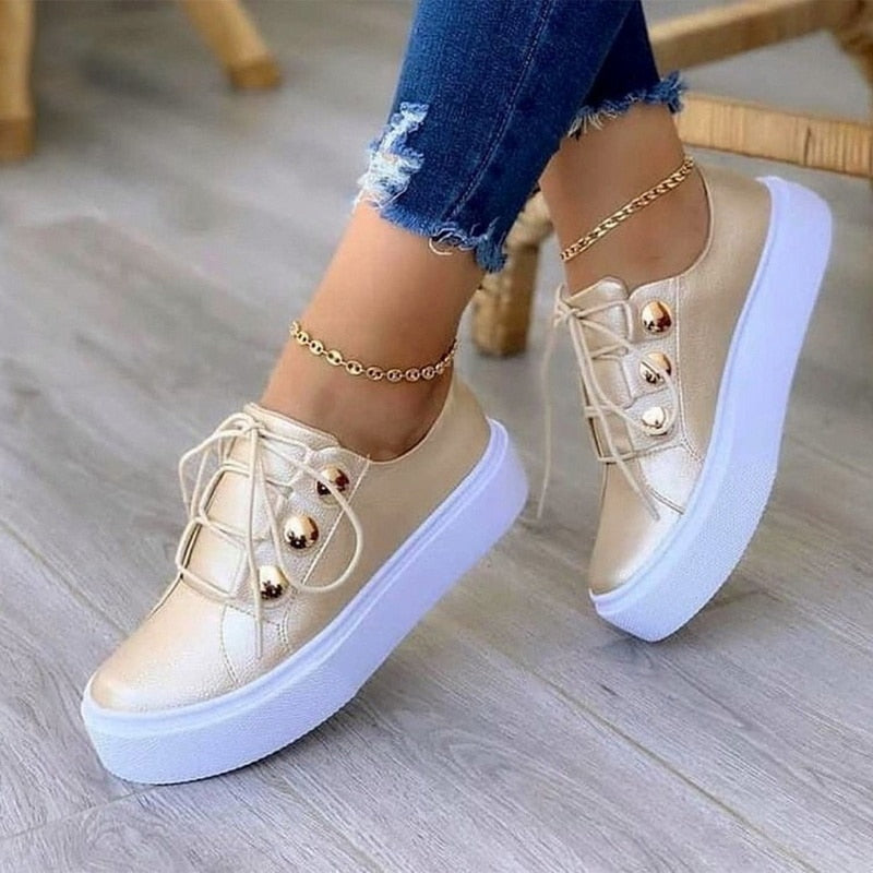 Light Breathable Female Running Shoes Casual Women Sneakers in gold with white sole, worn with jeans and ankle bracelet.