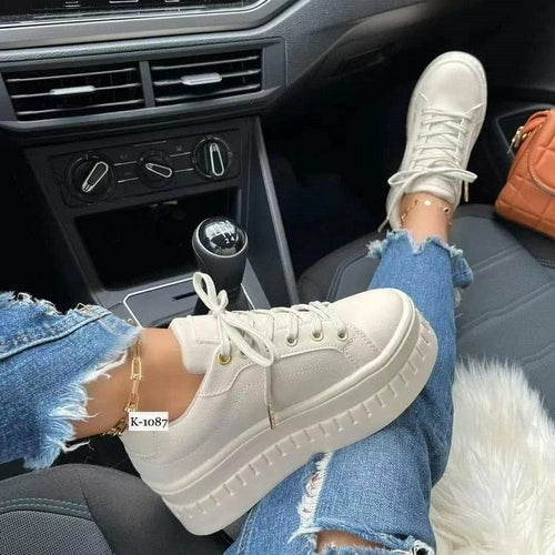 Casual platform women's sneakers worn in a car with ripped jeans and stylish accessories.