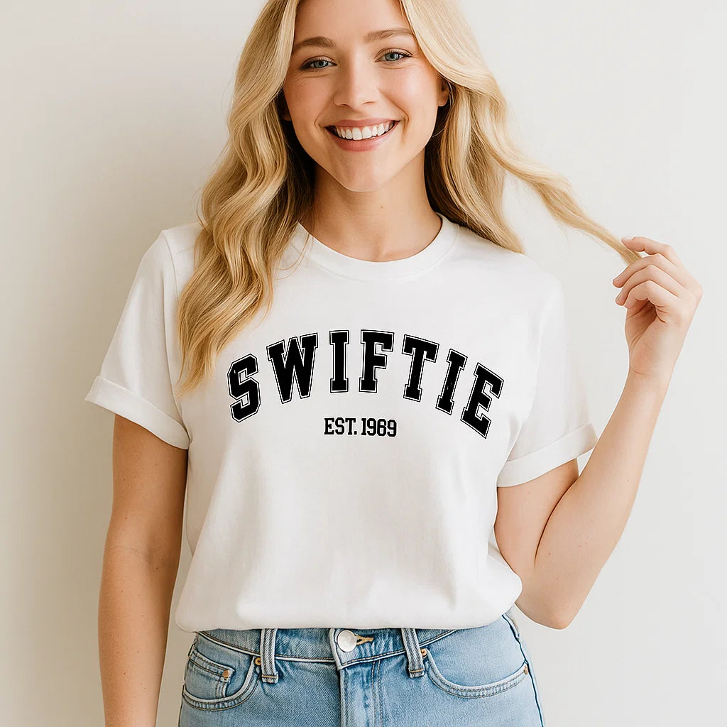 SWIFTIE EST. 1969 T-shirt Music Fan Tee Unisex worn by a smiling woman with blonde hair, showcasing casual style.